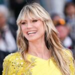 Heidi Klum lacht im gelben Kleid auf dem roten Teppich